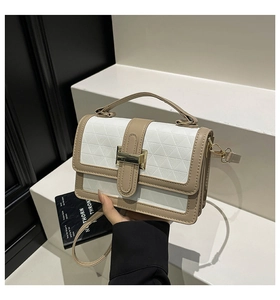 Detail of a chic contrast color handbag featuring geometric embossing and gold clasp