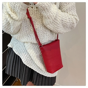 Detailansicht der roten Eimer-Tasche aus Leder mit Lychee-Muster und geknotetem Riemen