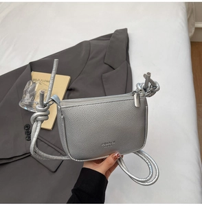 Close-up of silver lychee texture mini crossbody bag with a knotted shoulder strap detail