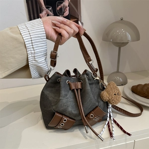 Retro drawstring bucket bag in grey denim and brown leather with bear charm and straps