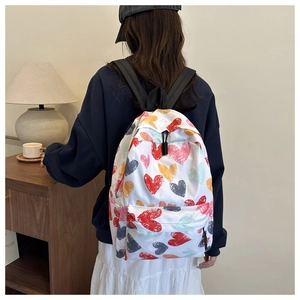 Detailed back view of a colorful heart graffiti print backpack with black straps