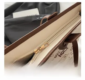 Gros plan sur la fermeture éclair dorée d'un sac cabas imprimé avec graffiti marron