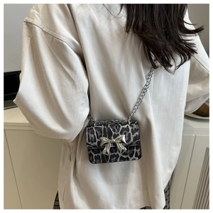 Detailed back view of a mini leopard print crossbody bag with silver bow on a white shirt
