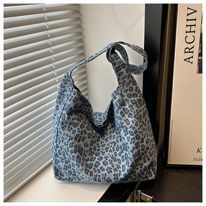 Vue détaillée du sac cabas en coton à imprimé léopard bleu sur une surface blanche