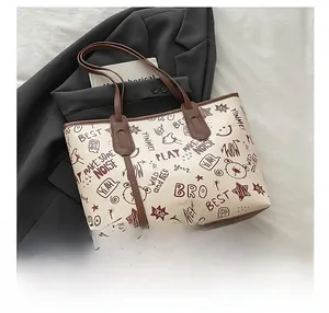 Détail d'un cabas imprimé avec motifs graffiti marron sur similicuir de couleur crème
