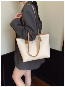 Detalle de bolso tote blanco grande con correas marrones y letras de NEW YORK en modelo