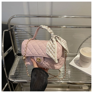 Detailed close-up of pink quilted crossbody bag featuring a silk scarf wrapped handle