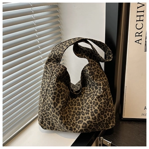 Gros plan détaillé du sac cabas vintage en toile léopard sous la lumière naturelle de la fenêtre