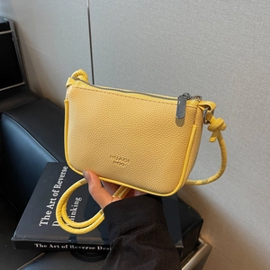Minimalist bright yellow cross-body phone bag with lychee texture and zipper closure