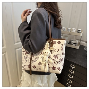 Détail du sac cabas en toile avec graffitis de dessins animés et pendentif lapin mignon