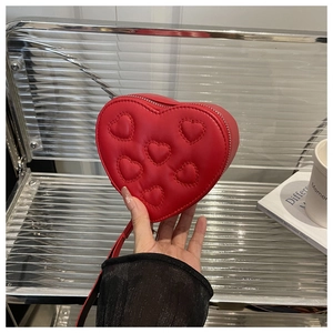 Detail showing the quilted heart pattern and texture of the red PU leather crossbody bag