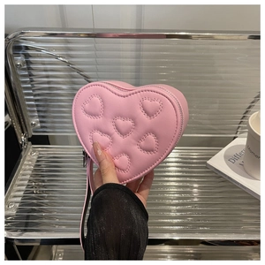 Close-up of a pink heart-shaped mini bag with embossed patterns and silver zipper