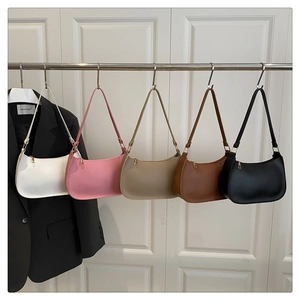 Hobo bags collection in white, pink, beige, brown, and black hanging on a metal rack