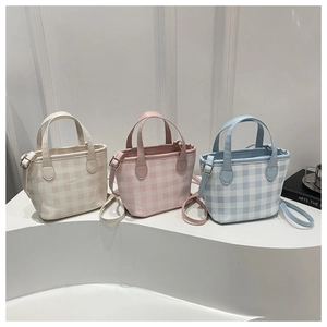 Detailed view of plaid tote bags in beige, pink and sky blue colors with leather handles