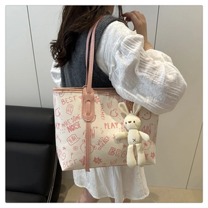 Détail du grand sac cabas blanc avec bandoulière rose, motifs arty et pendentif lapin