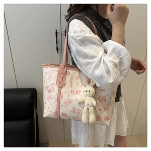 Détail du sac fourre-tout en toile crème avec imprimé ours et charm lapin en peluche