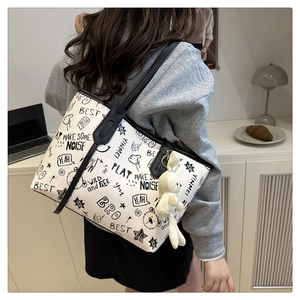 Détail du sac cabas blanc avec graffitis noirs et pendentif de lapin blanc mignon
