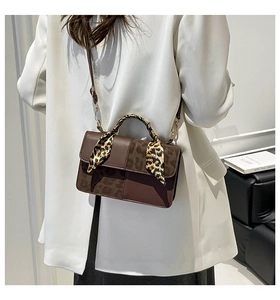 Detail of dark brown handbag with leopard print panel and silk scarf wrapped handle