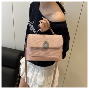 Détail du sac bandoulière rose avec rabat tissé et fermoir fer à cheval argenté
