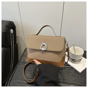 Détail de la texture tissée rétro et boucle fer à cheval argentée sur sac marron