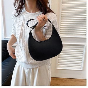 Detail shot of black crescent bag showing pebble leather texture and silver zipper