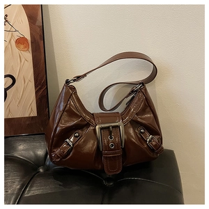 Détail du sac sous le bras en similicuir marron café brillant avec boucle en métal