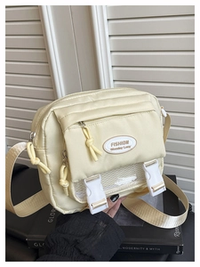 Detail of beige messenger bag with dual buckles and decorative mesh front pocket