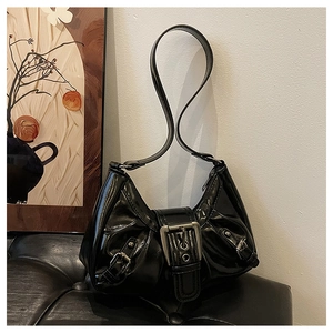 Gros plan d'un grand sac hobo noir brillant avec une boucle métallique vintage audacieuse