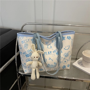 Grand sac cabas tendance avec imprimé graffiti bleu et breloque lapin sur étagère
