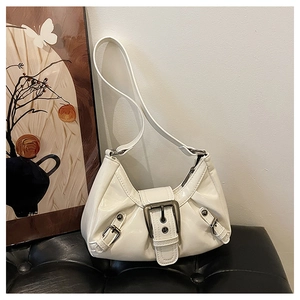 Detail of white patent leather shoulder bag with pleated texture and silver buckle