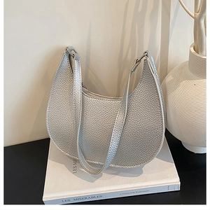 Detail of silver crescent shoulder bag with lychee texture and metallic finish