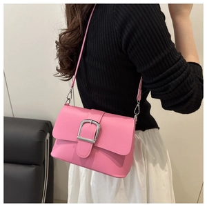 Close-up of pink PU leather flap bag with oversized silver metal buckle decoration