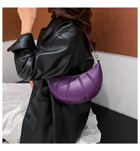 Purple crescent hobo bag with vertical pleats and gold hardware worn by a model