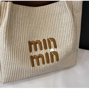 Detail shot of beige woven fabric with brown min min letter embroidery on tote bag