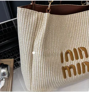 Detail of woven tote bag with embroidered logo and premium leather trim details