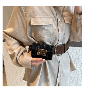 Detail of black croc-effect micro bag with gold chain and metal twist lock closure