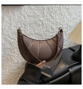 Detailed view of brown crescent bag with pleated leather and elegant gold buckle
