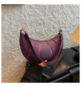 Detail view of purple crescent shoulder bag with vertical pleats and golden hardware