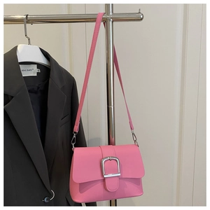 Detail shot of vintage pink leather square bag with a silver lock on an office blazer