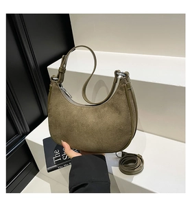 Close-up of olive green suede crescent bag with adjustable handle and crossbody strap