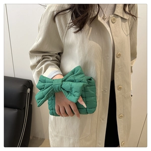 Detail of bright green quilted cloud bag featuring a large oversized bow design