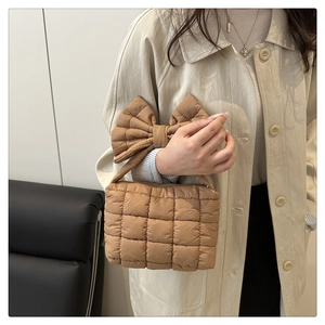 Borsa trapuntata in piumino con grande fiocco decorativo sul manico in un elegante marrone