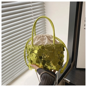 Detail of lime green sequin bucket bag with drawstring pouch and slim handle