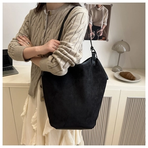 Vue détaillée du sac seau noir mat avec de fines bandoulières en cuir souple