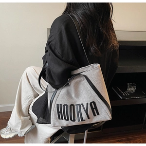 Detailed view of the large linen tote bag with black contrast handles and logo embroidery