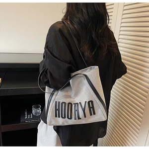 Close-up of HOOAYA canvas tote bag with black leather trim and minimalist brand logo