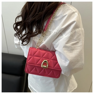 Détail du sac bandoulière matelassé fuchsia avec fermoir fer à cheval doré et chaîne