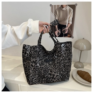 Detail view of leopard print tote bag with silver sheen and elegant black square label