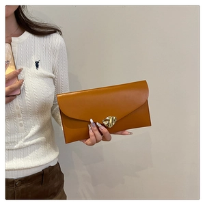 Close-up of caramel brown envelope clutch bag featuring a gold metallic irregular buckle