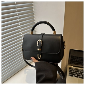 Détails d'un sac à main en cuir noir avec boucle dorée et bandoulière amovible